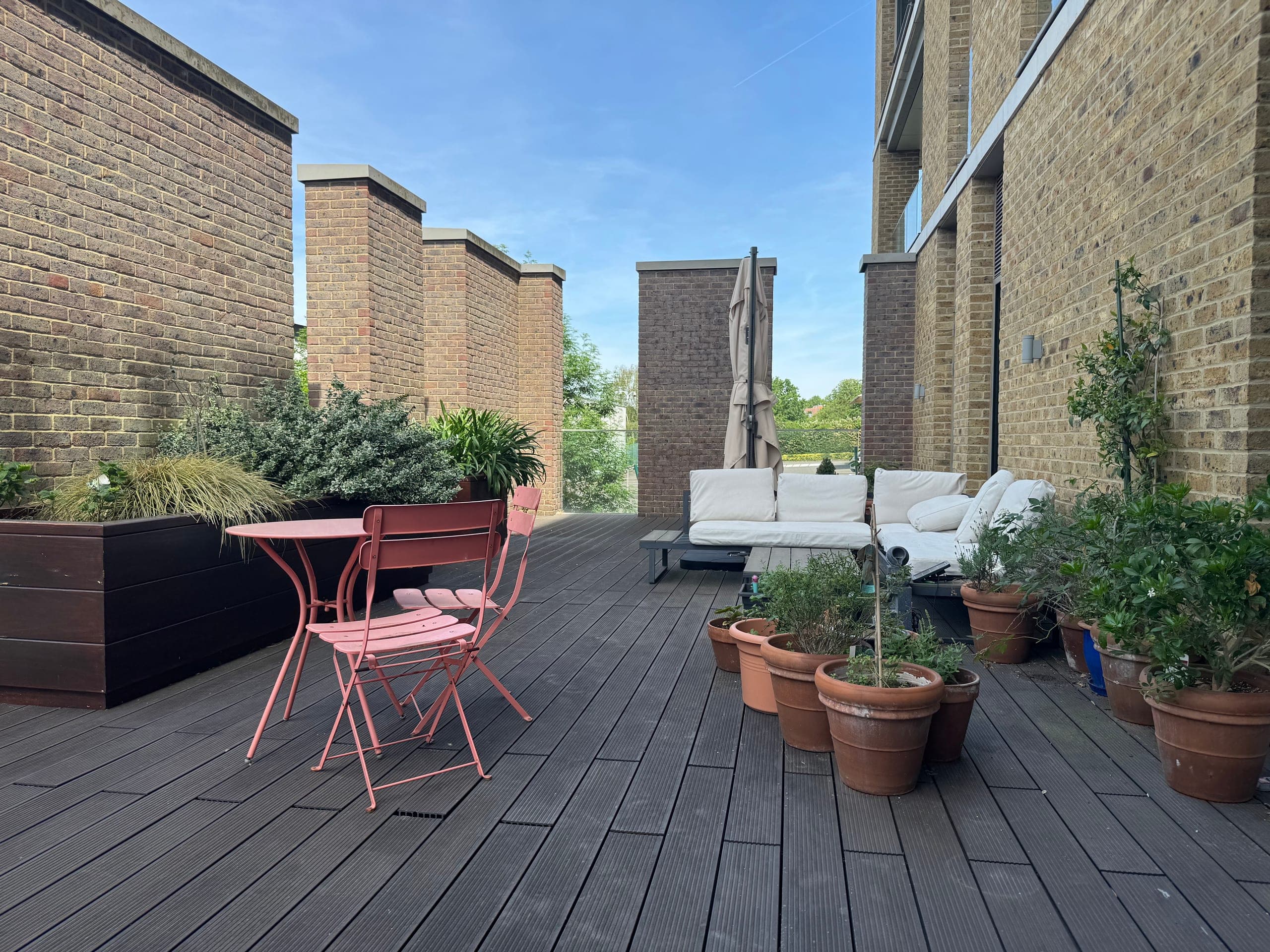 The terrace looking along its length, enclosed by brick walls and open to the trees at the far end
